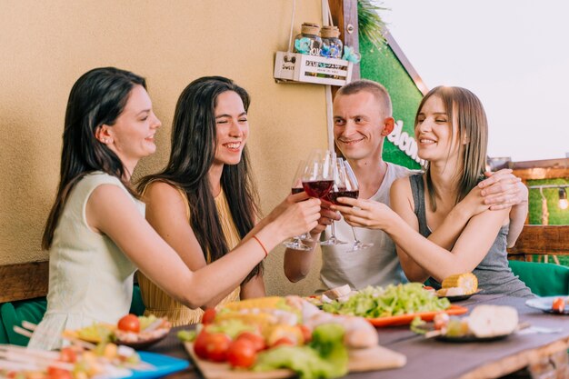 Gente brindando vino en una fiesta en la azotea