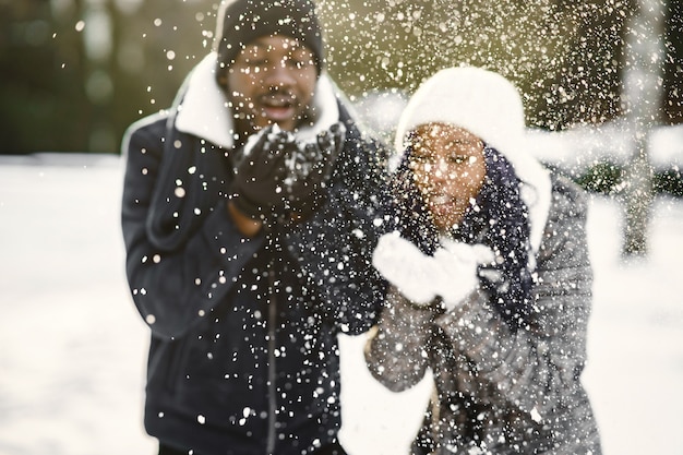 La gente camina afuera. Día de invierno. Pareja africana