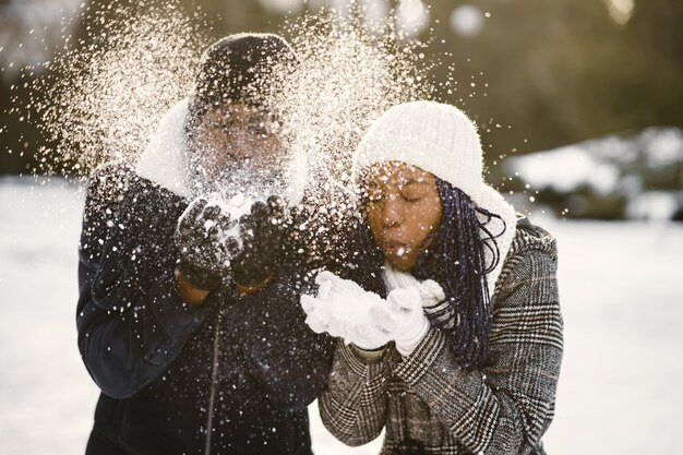 La gente camina afuera. Día de invierno. Pareja africana