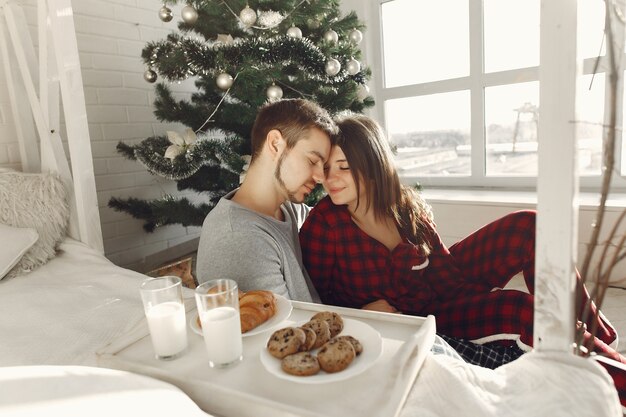 Gente en casa. Familia en pijama. Leche y croissants en una bandeja.