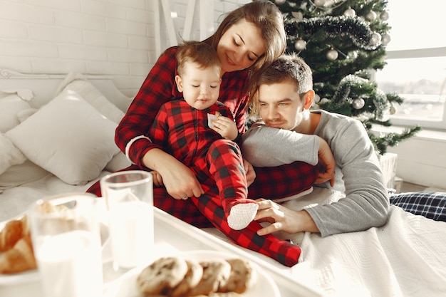 Gente en casa. Familia en pijama. Leche y croissants en una bandeja.