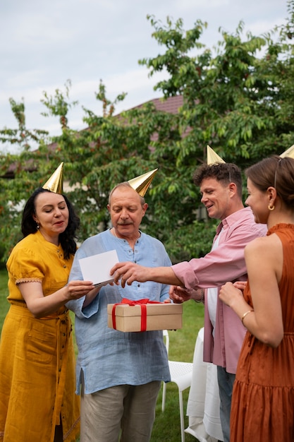 Gente celebrando una fiesta de cumpleaños al aire libre en el jardín