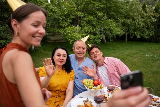 Gente celebrando una fiesta de cumpleaños al aire libre en el jardín