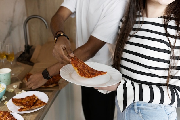 Gente celebrando en fiesta con pizza