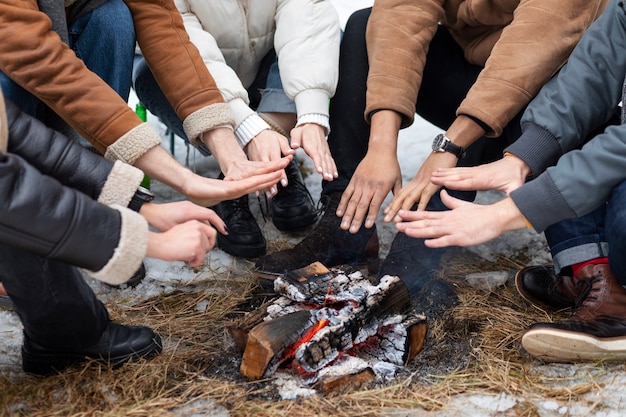 Foto gratuita gente cogida de la mano junto al fuego