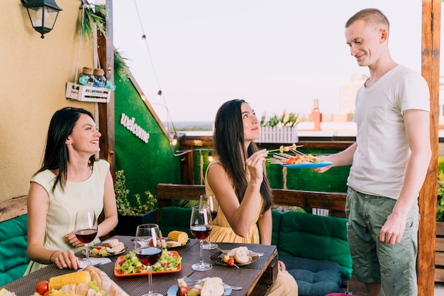 Gente comiendo aperitivos en la fiesta en la azotea