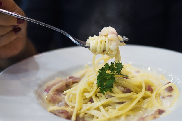 Gente comiendo espaguetis carbonara