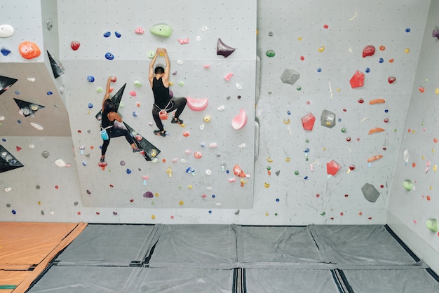 Gente deportiva trabajando en muro de escalada