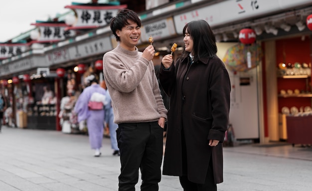 Foto gratuita gente disfrutando de la comida callejera japonesa