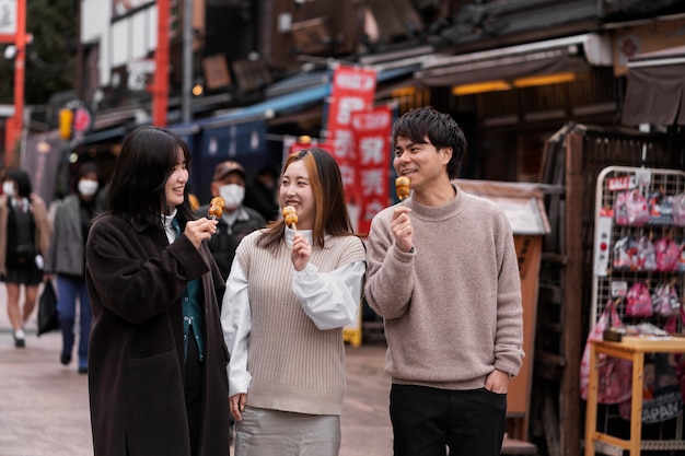 Foto gratuita gente disfrutando de la comida callejera japonesa