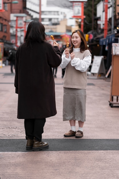 Foto gratuita gente disfrutando de la comida callejera japonesa