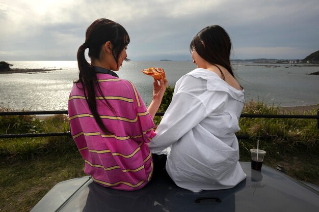 Gente disfrutando de pizza juntos al aire libre