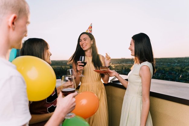 Gente disfrutando de vino y pastel en la azotea