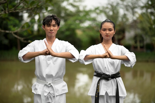 Foto gratuita gente entrenando juntos al aire libre para taekwondo