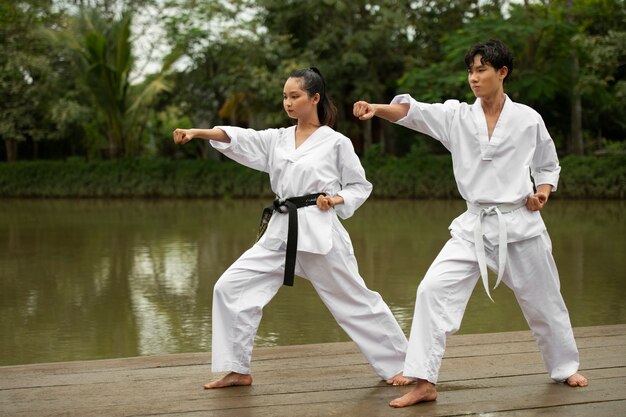 Gente entrenando juntos al aire libre para taekwondo