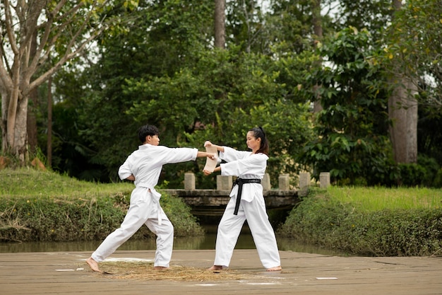 Gente entrenando juntos al aire libre para taekwondo