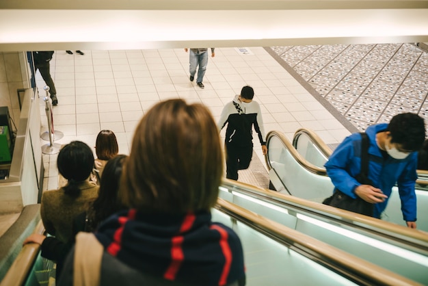 Gente en escaleras mecánicas en la ciudad.