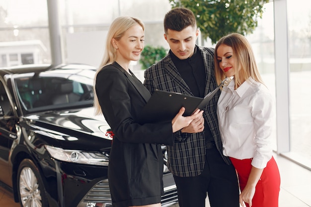 Foto gratuita gente con estilo y elegante en un salón de autos