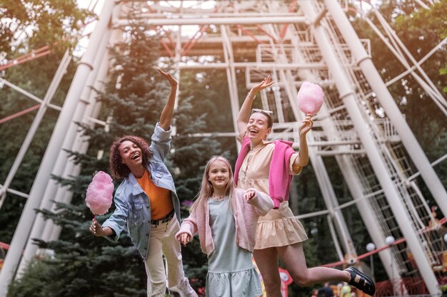 Gente feliz de ángulo bajo en el parque de atracciones