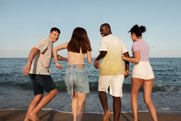 Gente feliz en la playa de tiro medio