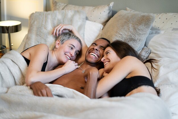 Gente feliz de tiro medio en la cama
