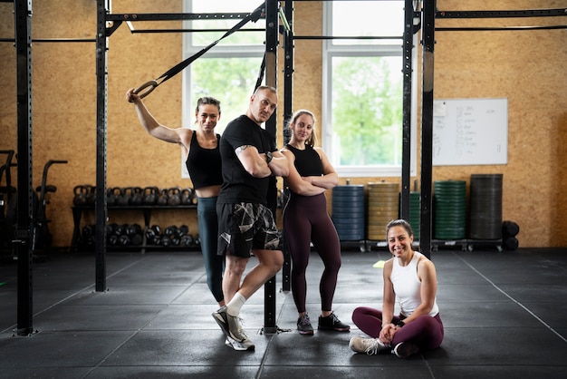 Foto gratuita gente en forma feliz de tiro completo en el gimnasio