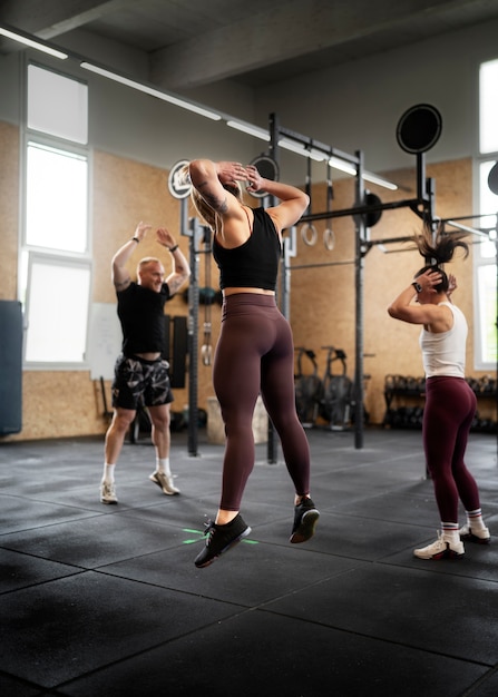 Foto gratuita gente en forma de tiro completo haciendo burpees juntos