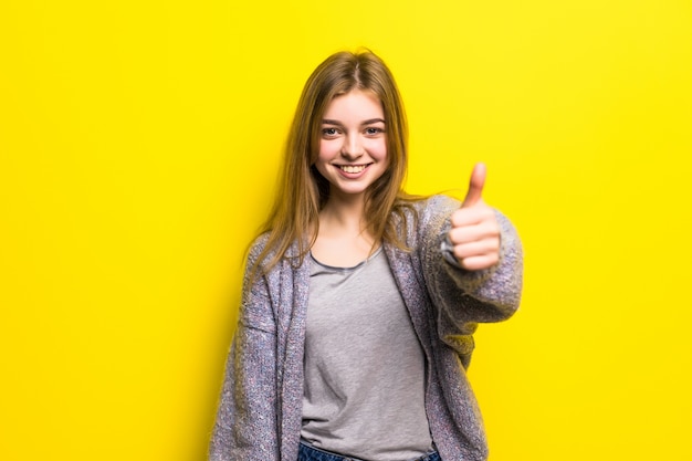 Gente, gesto, estilo y concepto de moda - mujer joven feliz o adolescente en ropa casual mostrando los pulgares para arriba