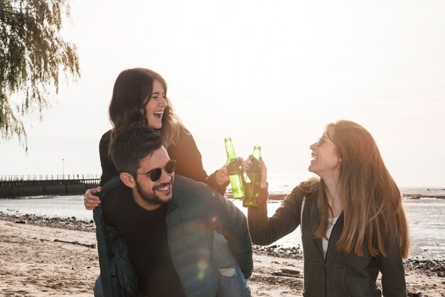 La gente golpea botellas de cerveza cerca del mar