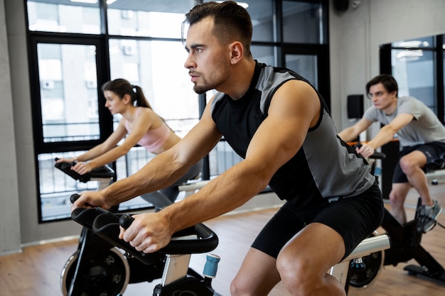 Foto gratuita gente haciendo ciclismo indoor