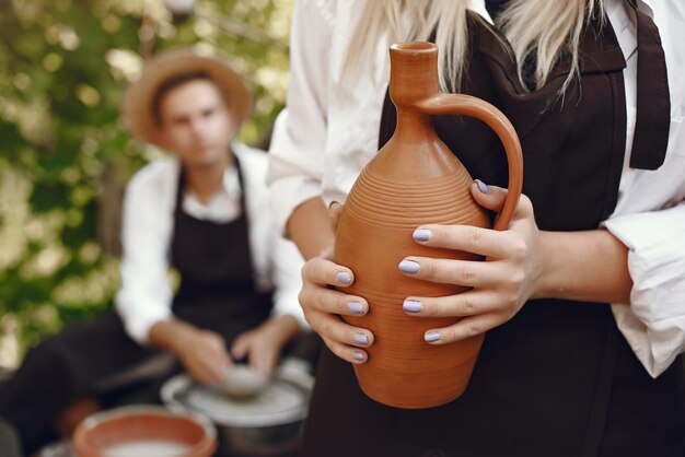 Gente haciendo jarrones con arcilla