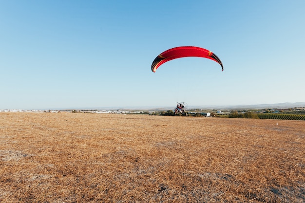 Foto gratuita gente impulsada por parapente en el cielo