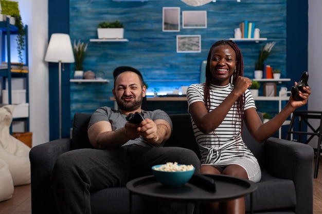 Gente interracial alegre ganando videojuegos en tv