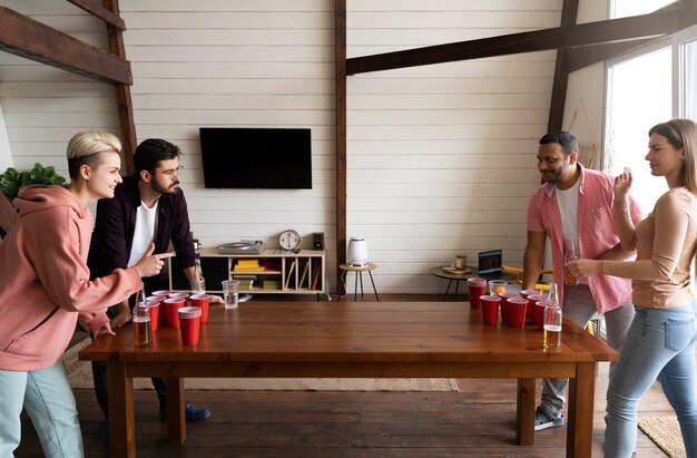 Gente jugando al beer pong en una fiesta interior