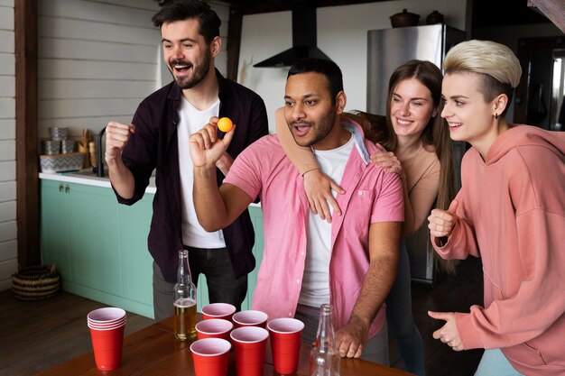 Gente jugando al beer pong en una fiesta interior