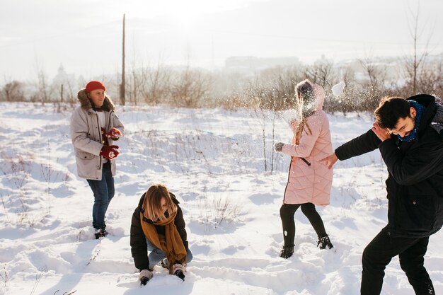 Gente jugando bolas de nieve en el bosque de invierno