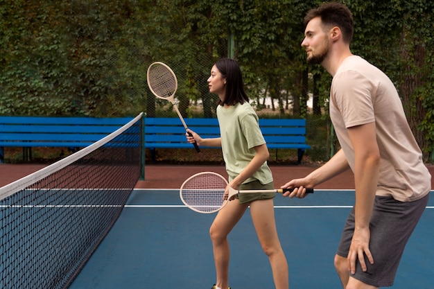 Foto gratuita gente jugando vista lateral de bádminton