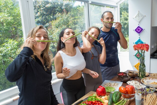 Gente juguetona haciendo bigote falso de espárragos.