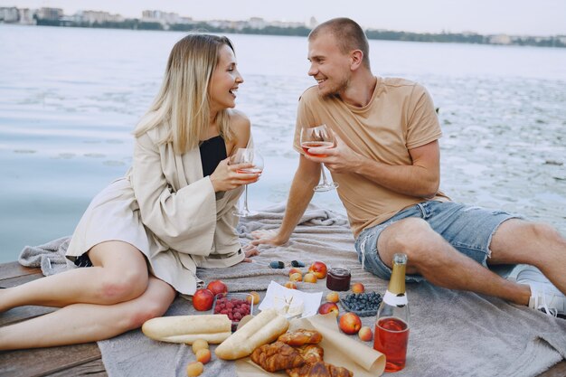 Gente junto al río. Picnic de verano saludable delicioso en la hierba. Frutas en blancet.