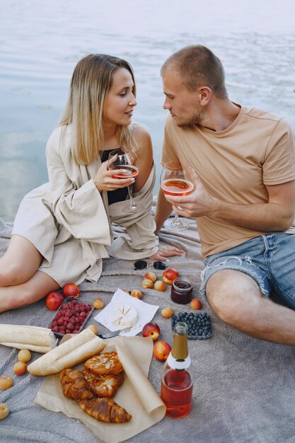 Gente junto al río. Picnic de verano saludable delicioso en la hierba. Frutas en blancet.