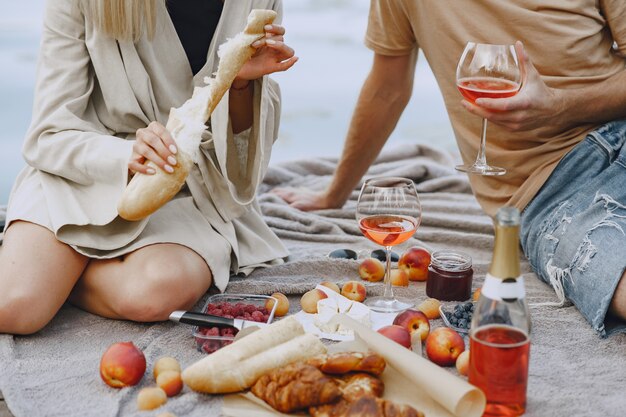 Gente junto al río. Picnic de verano saludable delicioso en la hierba. Frutas en blancet.