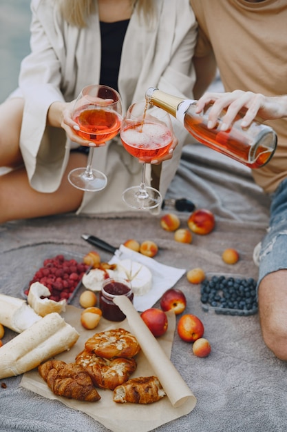 Gente junto al río. Picnic de verano saludable delicioso en la hierba. Frutas en blancet.