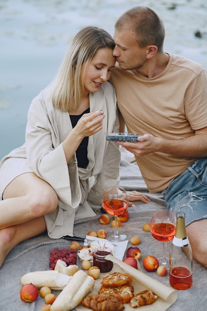 Gente junto al río. Picnic de verano saludable delicioso en la hierba. Frutas en blancet.