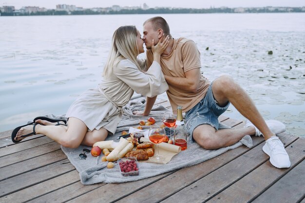 Gente junto al río. Picnic de verano saludable delicioso en la hierba. Frutas en blancet.