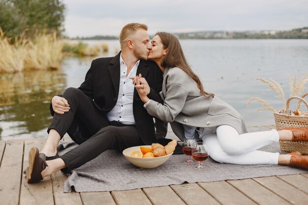 Gente junto al río. Picnic de verano saludable delicioso en la hierba. Frutas en blancet.