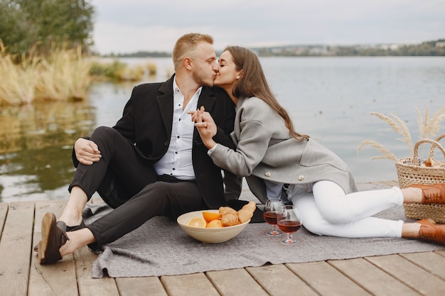 Gente junto al río. Picnic de verano saludable delicioso en la hierba. Frutas en blancet.