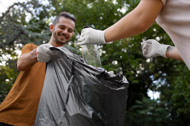 Foto gratuita gente limpiando basura de la naturaleza.