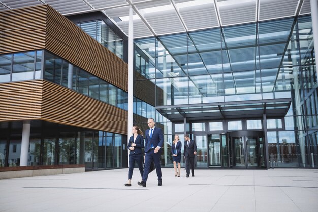 Gente de negocios caminando fuera del edificio de oficinas