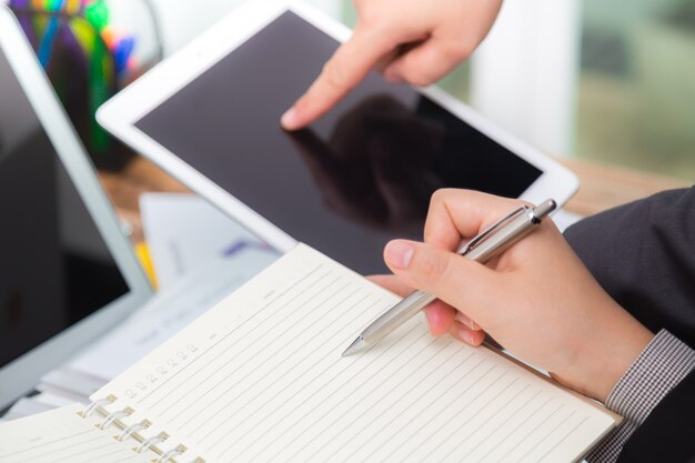 Gente de negocios comparando resultados en una tablet