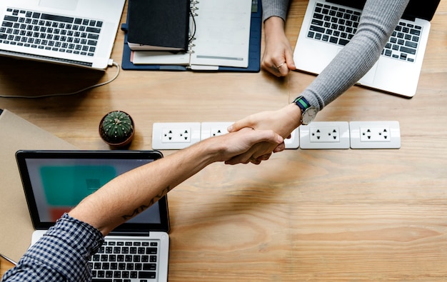 Foto gratuita gente de negocios dándose la mano de acuerdo